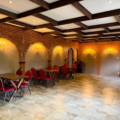 Sala restauracyjna z drewnianym stropem i rzędem stolików